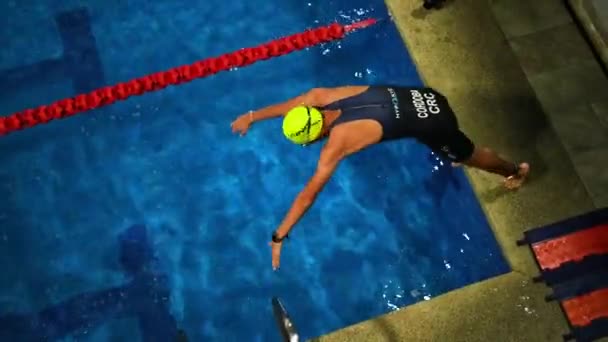 游泳者慢动作地跳入游泳池的深水中 身穿蓝色游泳池的泳衣 — 图库视频影像