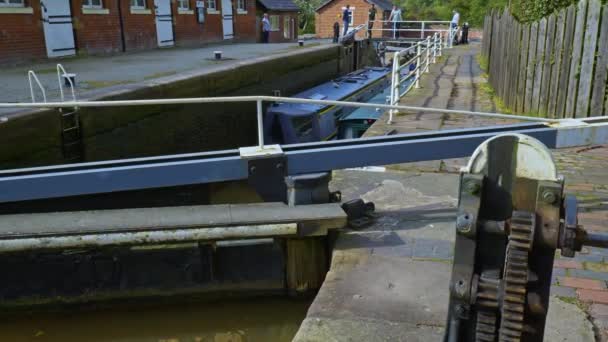 Bunbury Cheshire Shropshire Union Canal Seriesのクリップでロックシステムに入る2人の従業員の狭いボート — ストック動画