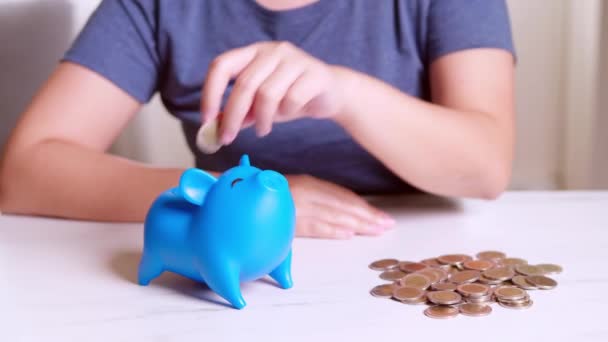 Tangan Wanita Menempatkan Koin Dalam Celengan Biru Konsep Keuangan — Stok Video