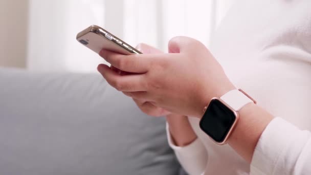 Close Van Hand Vrouw Met Behulp Van Smartphone Smartwatch Woonkamer — Stockvideo