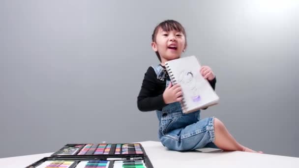 彼女が描いた絵でノートを見せる子供 子供の芸術の概念 — ストック動画