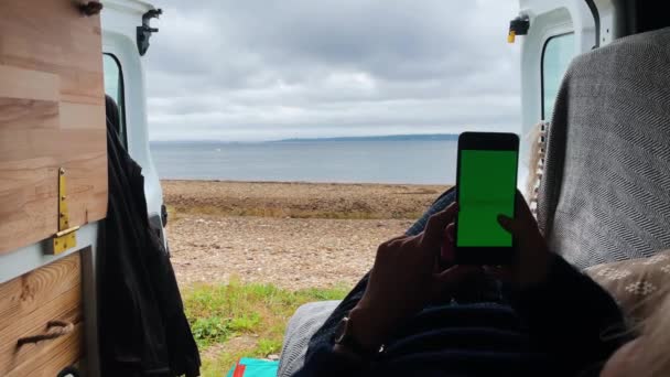 Młoda Kobieta Leżąca Vanie Patrząc Zielony Ekran Smartfona Przed Morzem — Wideo stockowe