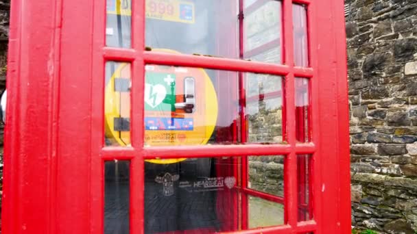 Lékařská pohotovost kardiologie defibrilátor zařízení ve staré červené britské veřejné vesnice telefon box široká pravá dolly