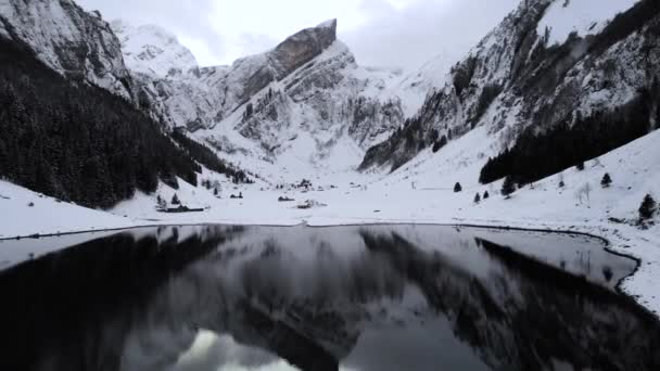 冬季的一天 瑞士阿彭策尔市 空中飞越塞雷普斯湖 四周都是雪 平静的水面上映照着阿尔普斯泰因峰 — 图库视频影像