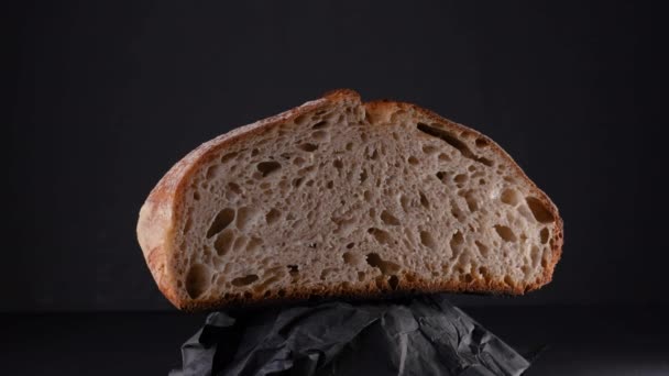 Vágás Sourdough Kenyér Gyűrött Papír Forgó Fekete Háttér Közelről Stúdió — Stock videók