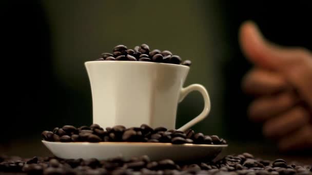 Mano Con Granos Café Vertiendo Una Taza Con Fondo Negro — Vídeos de Stock