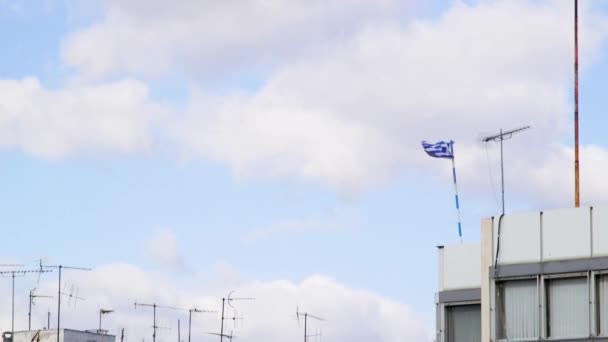 希腊雅典市中心一座建筑物的顶部悬挂着金属天线和希腊国旗 — 图库视频影像