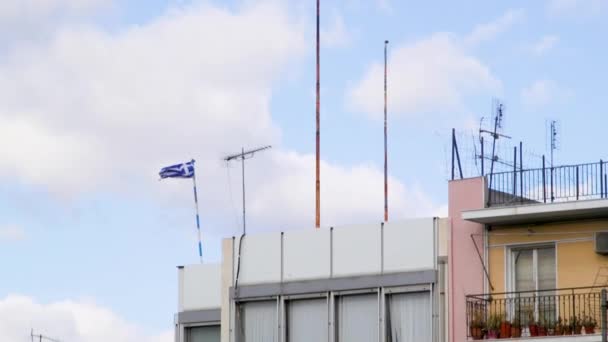 希腊雅典市中心一座建筑物的顶部悬挂着希腊国旗和天线 — 图库视频影像