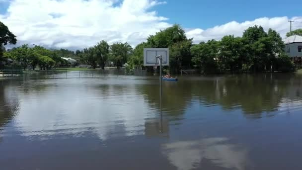 Luftaufnahme Eines Überfluteten Basketballfeldes Und Kinder Die Mit Einem Kanu — Stockvideo