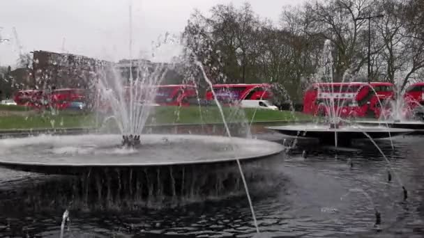 水上噴水の後ろにダブルデッキバスや車で忙しい英国の通り — ストック動画