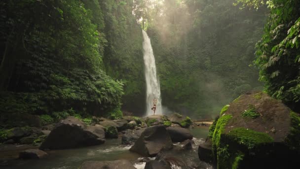 Mulher Praticando Árvore Posar Pedra Magnífica Cachoeira Nungnung Com Luz — Vídeo de Stock