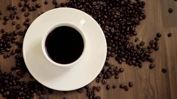 šálek horké černé kávy na stole s kávovými zrny na stole stock video