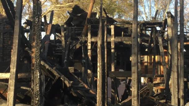 阳光照射在残存的烧焦的木结构和被大火烧毁的住宅的红砖壁炉上 — 图库视频影像
