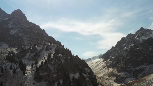 カザフスタンのトランス アラタウ山脈の雪に覆われた山の映画の回転するドローンショット — ストック動画