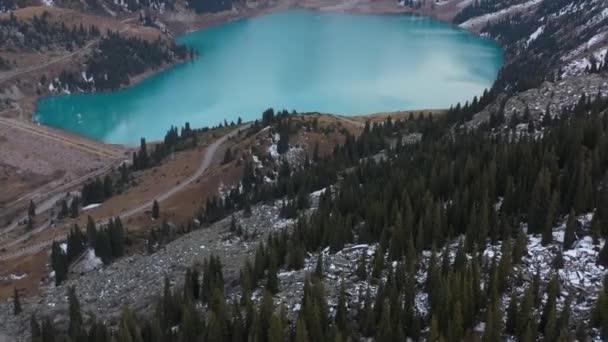 カザフスタンのトランス アラタウ山脈で 森の上から始まるビッグ アルマトイ湖のドローン映像を明らかにする映画 — ストック動画