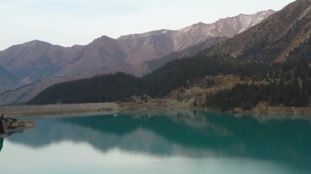 大アルマティ湖とカザフスタンのトランス アラタウ山脈のターコイズ色の湖の水のサイドドローン映像 — ストック動画