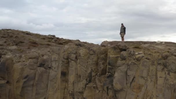 Epic Shot Young Man Standing Edge Cliff Aerial Flying Him — Vídeos de Stock