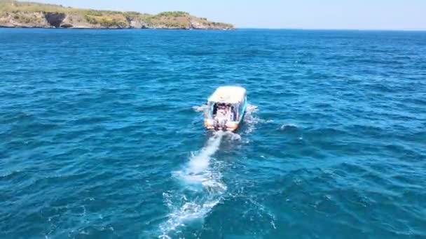 岩の多い海岸近くの海を航行する観光用モーターボート — ストック動画