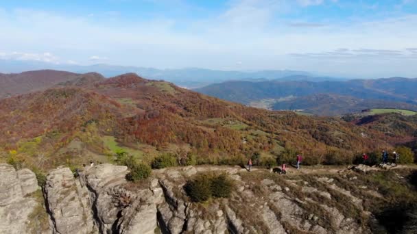 いくつかのハイカーは 秋のシーズンには非常に狭い山のクレストに沿って歩く 黄色の木々 周囲の山々 谷と森 — ストック動画