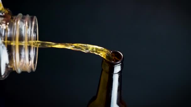 Tiro Vertical Cerveza Vertiendo Botella Vidrio Fondo Llano Cerca — Vídeo de stock