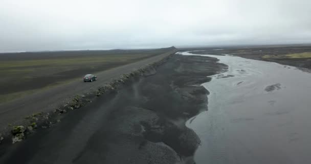 冰岛的汽车沿着黑沙的河流行驶在泥泞的路上 — 图库视频影像