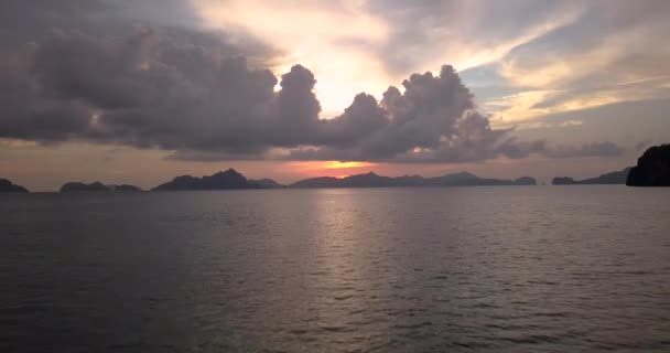 雲や山を越えて波によって夕日 Aerial — ストック動画