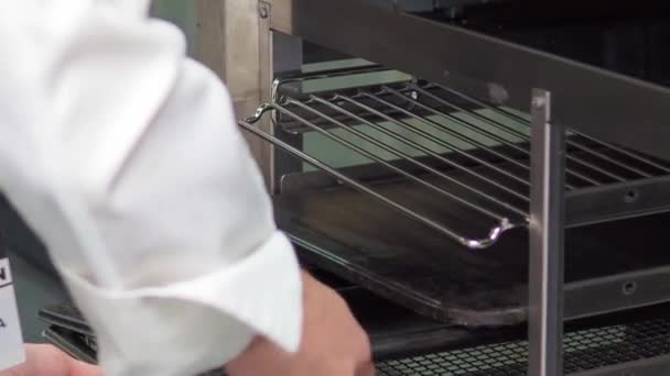 厨师从厨房托盘推车中取出烤盘 — 图库视频影像