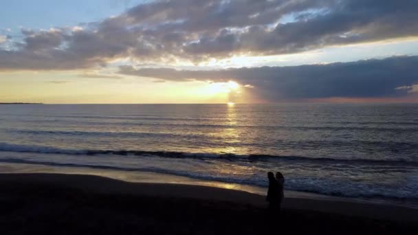 カップルはアルバニア海岸沿いのアドリア海の海岸線に沿って日没時に空中を歩き — ストック動画