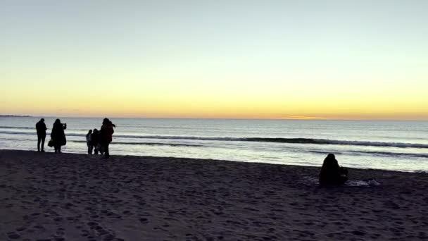 人々はアルバニアの海岸線に沿って日没を見る — ストック動画
