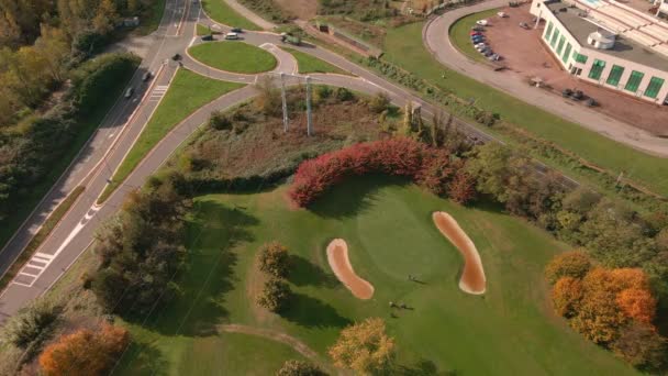 一个阳光明媚的秋日 高尔夫球场的空中景观和在村内转角处和道路上开车的交通 — 图库视频影像