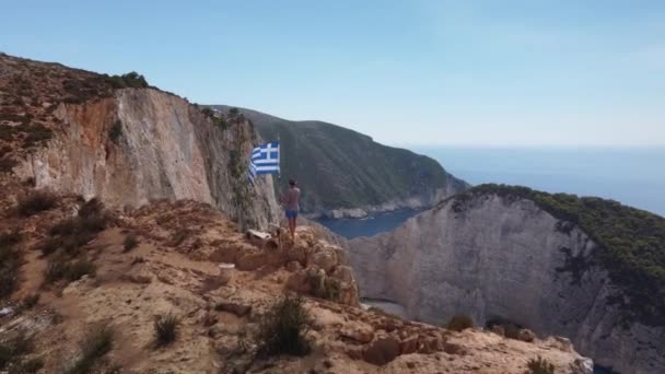 Mulher Branca Com Bandeira Grega Penhasco Praia Zakynthos Vista Aérea — Vídeo de Stock