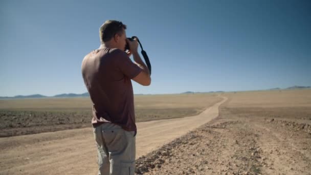 Foto Portátil Fotógrafo Deserto Tirando Uma Foto Paisagem África Enquanto — Vídeo de Stock