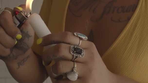 Μια Νεαρή Γυναίκα Ένα Κίτρινο Φόρεμα Τατουάζ Και Δαχτυλίδια Ανάβει — Αρχείο Βίντεο