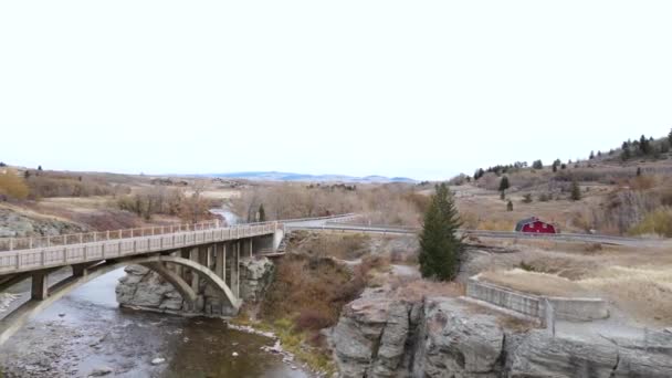 秋天的阴天 空中拍摄摄影机在艾伯塔省南部最拥挤的河流上移动 无人机拍摄揭示了连接干旱景观中两个陡峭河岸的旧桁架桥 — 图库视频影像