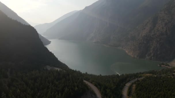 美しい晴れた日に両側に緑豊かな植生を持つ山脈の麓にある湖の美しい空の景色 — ストック動画