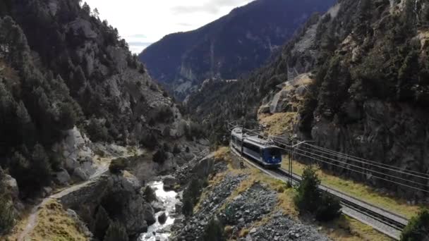 ピレネー山脈の青いラック列車が川に接近し 非常に狭い谷を渡る — ストック動画