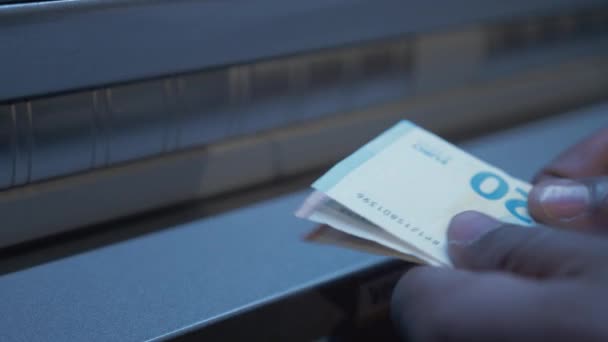 Refugee inserting banknotes into ATM bank machine. CLOSE UP 4K