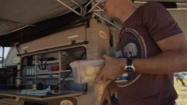 Tracking Shot Tourist Putting Food Products Fold Out Table Rental — Vídeo de stock