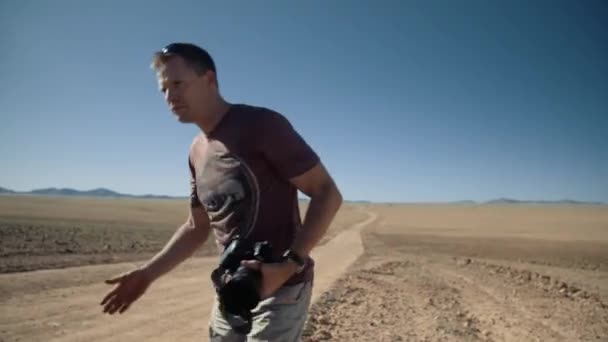 Handheld Dynamic Tracking Shot Photographer Tourist Putting His Sunglasses Walking — Stock Video