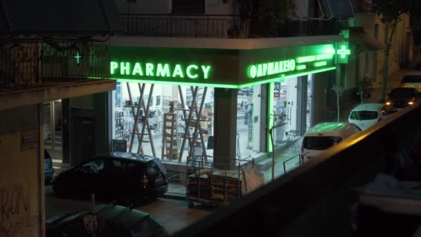 夜にアテネで開かれた明るい目を引くネオンサインを持つ薬局 — ストック動画