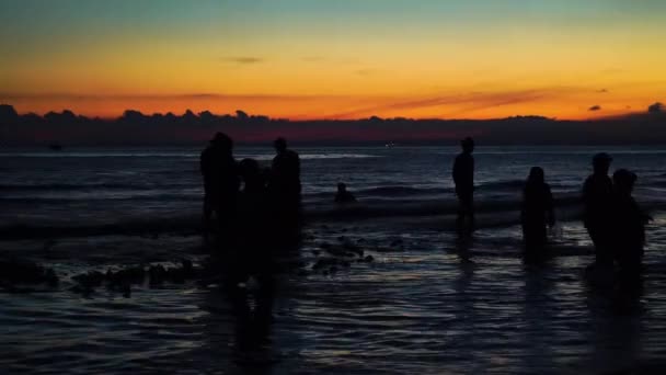 夕暮れ時に巨大な漁網で魚を釣る海で働く漁師たちのシルエット — ストック動画