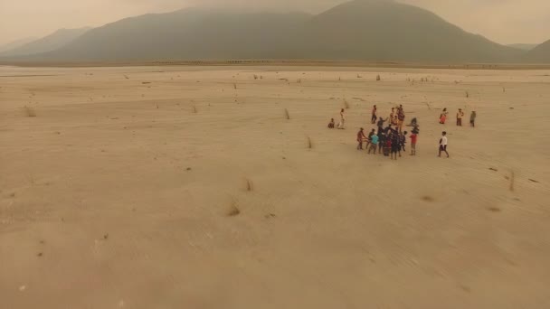 沙漠无人驾驶航空器轨道摄制组人员携带生产设备 背景为死火山 带有暖落落Lut级 — 图库视频影像