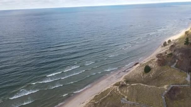空中トラック運動 マスキーゴンの砂丘の海岸線に打ち寄せる柔らかい波を披露する — ストック動画