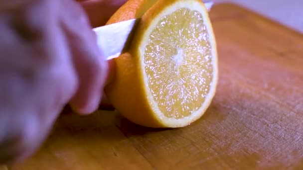 Vista Mano Cortando Una Rebanada Naranja Una Tabla Madera Cerca — Vídeos de Stock