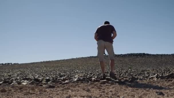 Широкоугольный Снимок Туриста Фотографа Приседающего Сфотографироваться Скалистой Пустыне Африки — стоковое видео