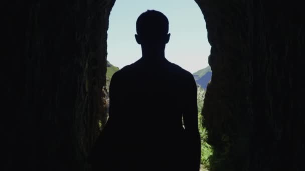 男は劇的な山の風景 スローモーションを明らかにするためにトンネルから出て歩く — ストック動画