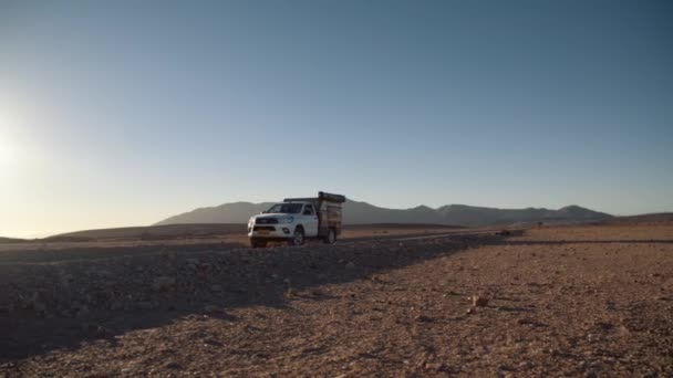 アフリカの砂漠に立つオフロードキャンプ車両の手持ちパン — ストック動画