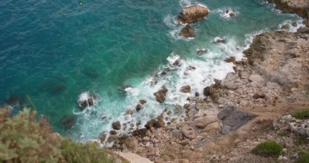 海岸の岩を打つ青い水の高角度ビデオショット — ストック動画