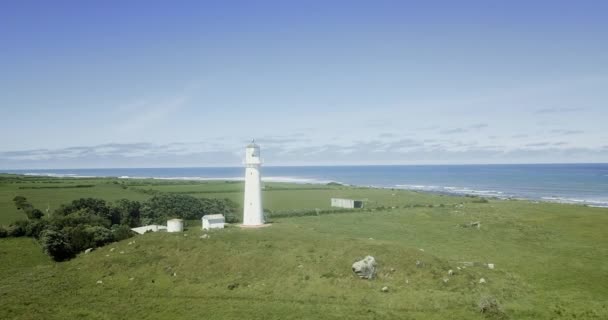 エグモント岬灯台と豊かな緑の農地へのフライト ニュージーランド — ストック動画