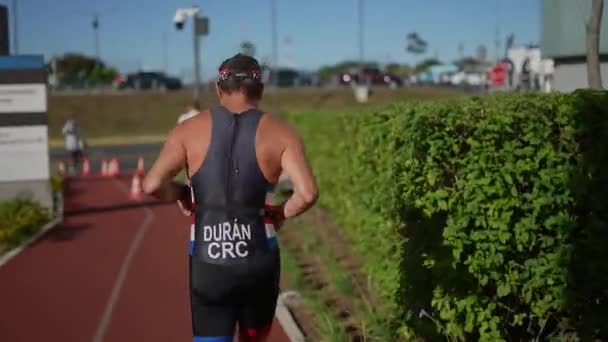 Άντρας Αθλητής Τρέχει Στο Στίβο Δρομέας Πίσω Στο Τρίαθλο Διαγωνισμό — Αρχείο Βίντεο